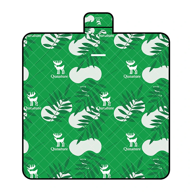 A Qunature branded outdoor picnic mat with a patterned design featuring elements like mountains, trees, and camping gear, in green, beige, and other colors.