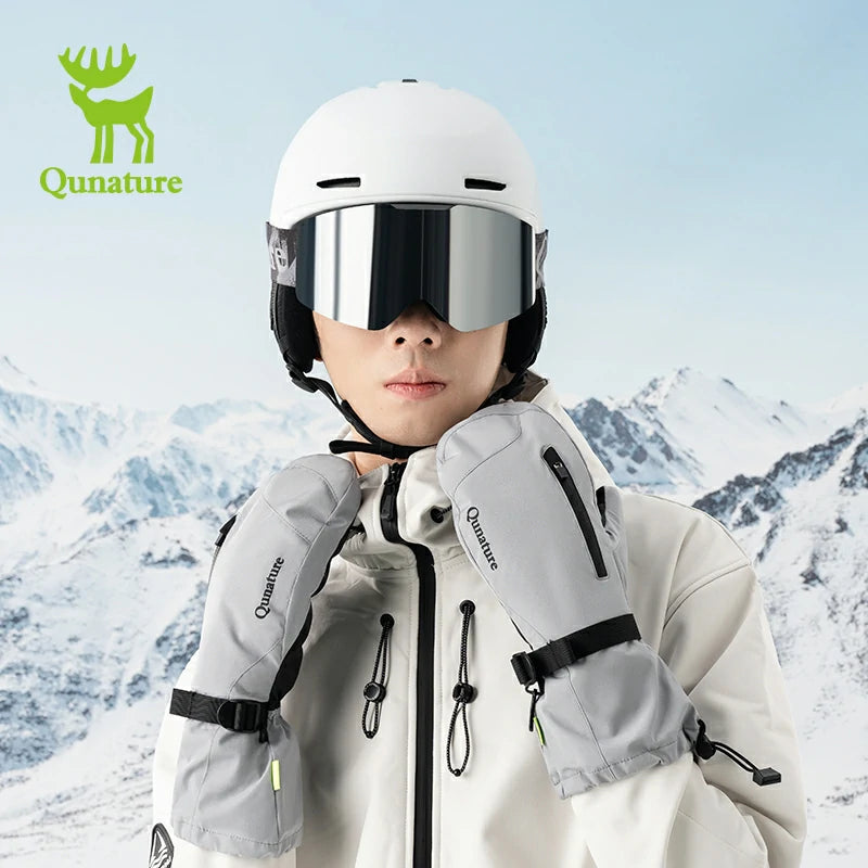 A man wearing ski goggles and gray ski gloves touching his collar in the snow