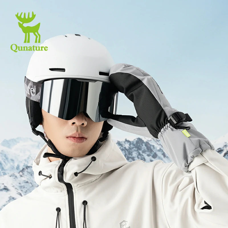 A man wearing ski goggles and gray ski gloves in the snow